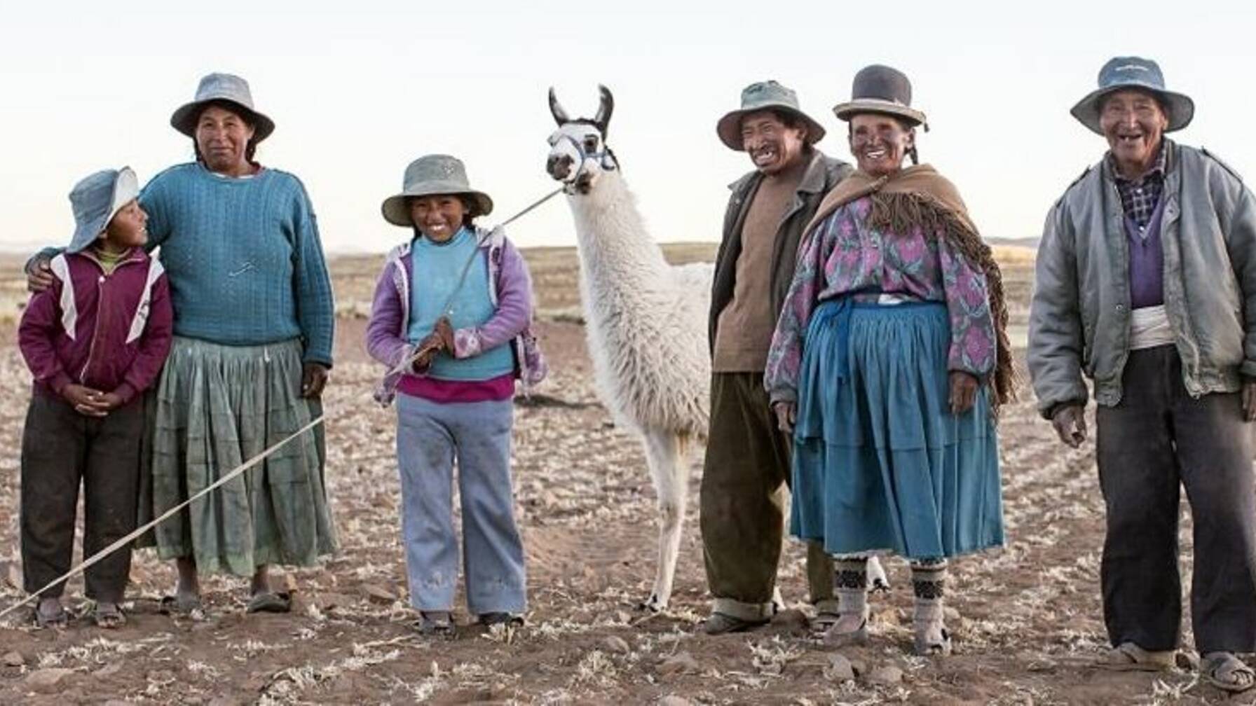 Sechsköpfige Familie in den Anden mit zwei Lamas.